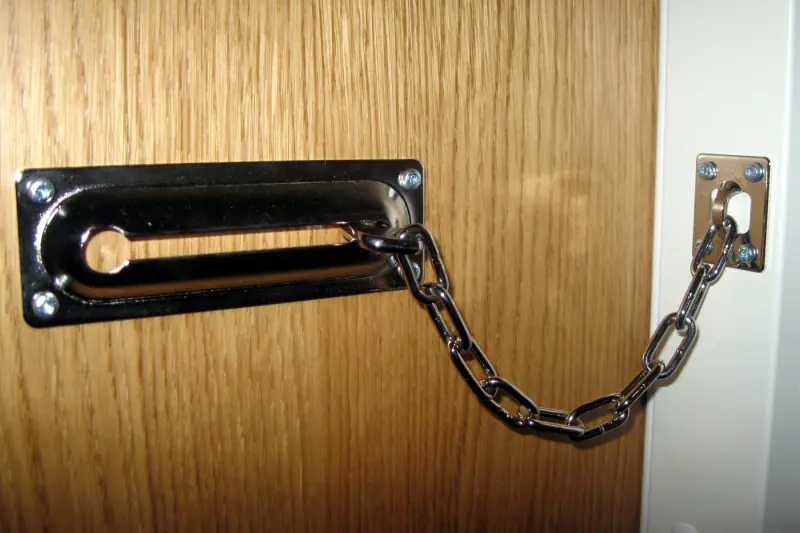 Een deurketting op een houten deur